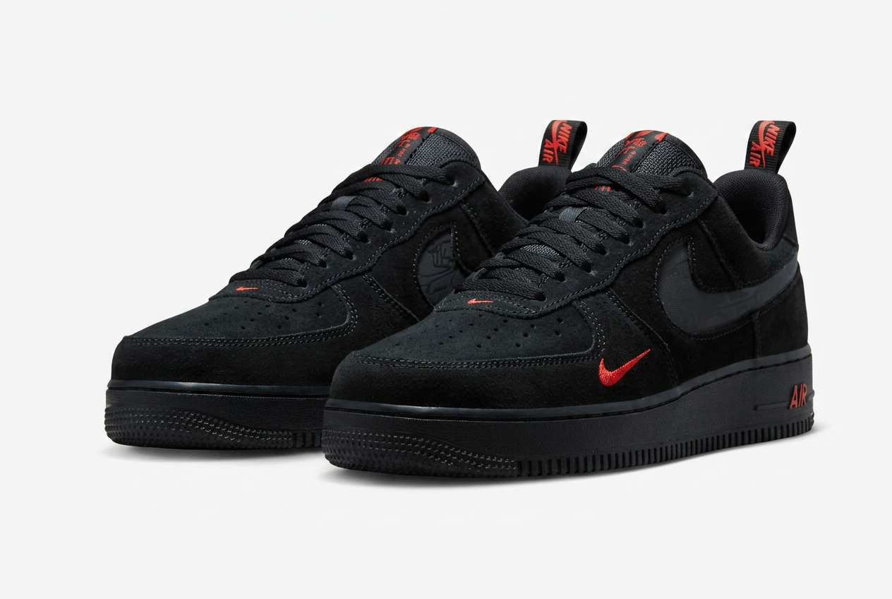 Nike Air Force 1 Low in black suede with crimson Swoosh accents, pair on white background