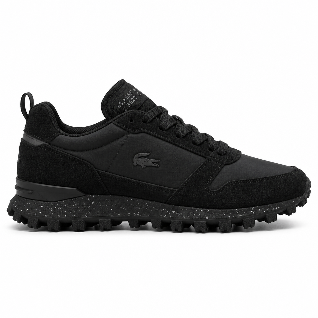 All-black stealth trail sneaker with speckled midsole and lug outsole on a plain white background