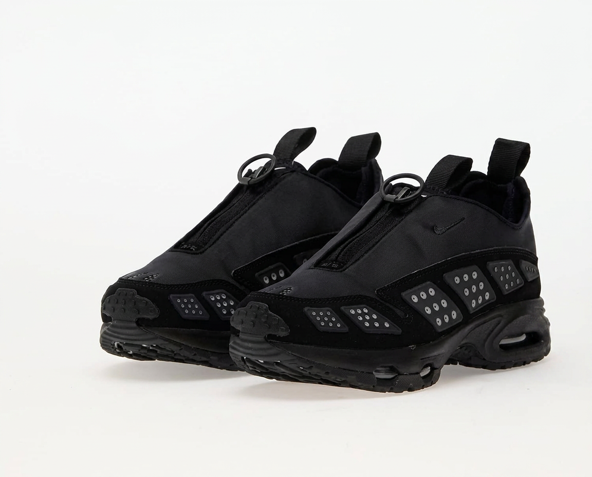 Nike Air Max Sunder zip shroud sneakers in triple black nylon with studded panels on white background