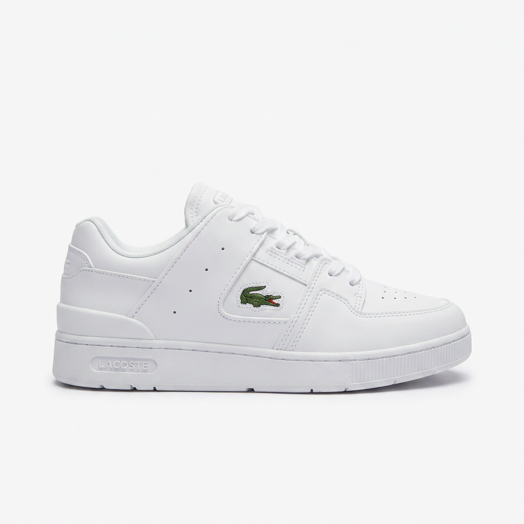All white leather court sneaker with small green crocodile logo on a plain white background